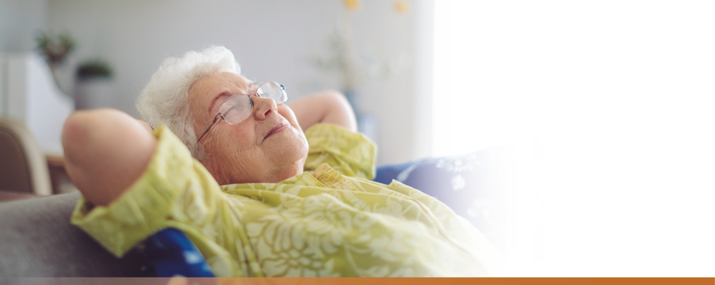 Senior woman reclining with eyes closed and a smile on her face.